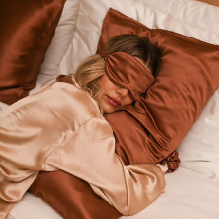 Woman sleeping peacefully on a Sillo silk pillowcase made from hypoallergenic, silver-infused mulberry silk that helps block allergens, reduce bacteria buildup, and soothe sensitive skin for a cleaner, more restful sleep.