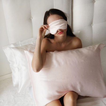 A woman relaxing on a blush pink Sillo silk pillowcase, crafted from 22-Momme silver-infused mulberry silk that helps prevent acne, reduce bacteria, and maintain hydrated, healthy skin.