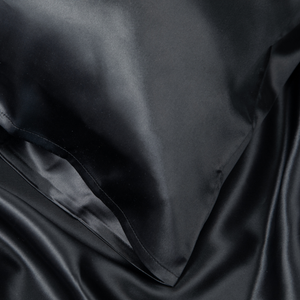 Close-up of Black Sillo silk pillowcase — 22 Momme 6A grade organic Mulberry silk woven with silver ions for antibacterial protection, showing smooth texture, envelope-style closure, and natural sheen; gentle on skin and hair.