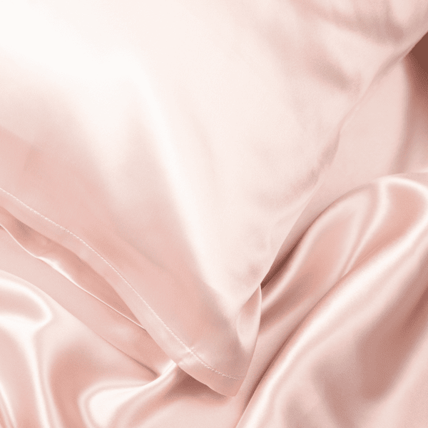 Close-up of Blush Pink Sillo silk pillowcase — 22 Momme 6A grade organic Mulberry silk woven with silver ions for antibacterial protection, showing smooth texture, envelope-style closure, and natural sheen; gentle on skin and hair.