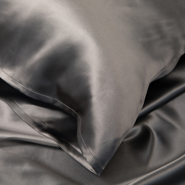 Close-up of Charcoal Grey Sillo silk pillowcase — 22 Momme 6A grade organic Mulberry silk woven with silver ions for antibacterial protection, showing smooth texture, envelope-style closure, and natural sheen; gentle on skin and hair.