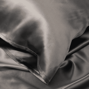 Close-up of Charcoal Grey Sillo silk pillowcase — 22 Momme 6A grade organic Mulberry silk woven with silver ions for antibacterial protection, showing smooth texture, envelope-style closure, and natural sheen; gentle on skin and hair.