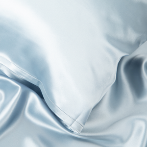 Close-up of Haze Blue Sillo silk pillowcase — 22 Momme 6A grade organic Mulberry silk woven with silver ions for antibacterial protection, showing smooth texture, envelope-style closure, and natural sheen; gentle on skin and hair.