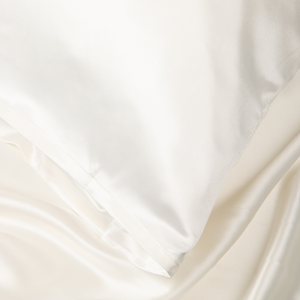 Close-up of Ivory White Sillo silk pillowcase — 22 Momme 6A Grade organic Mulberry silk woven with silver ions for antibacterial protection, showing smooth texture, envelope-style closure, and natural sheen; gentle on skin and hair.