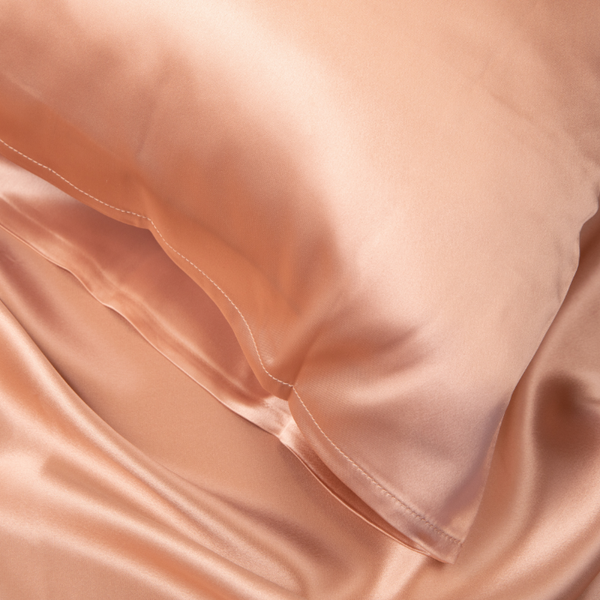 Close-up of Rose Pink Sillo silk pillowcase — 22-Momme 6A grade organic Mulberry silk woven with silver ions for antibacterial protection, showing smooth texture, envelope-style closure, and natural sheen; gentle on skin and hair.