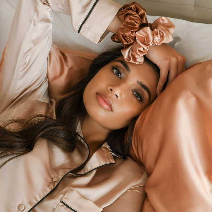 Lifestyle image of woman sleeping on Rose Pink Sillo silk pillowcase — smooth, temperature-regulating silk that helps prevent acne, wrinkles, frizz, breakage, while caring for sensitive skin.