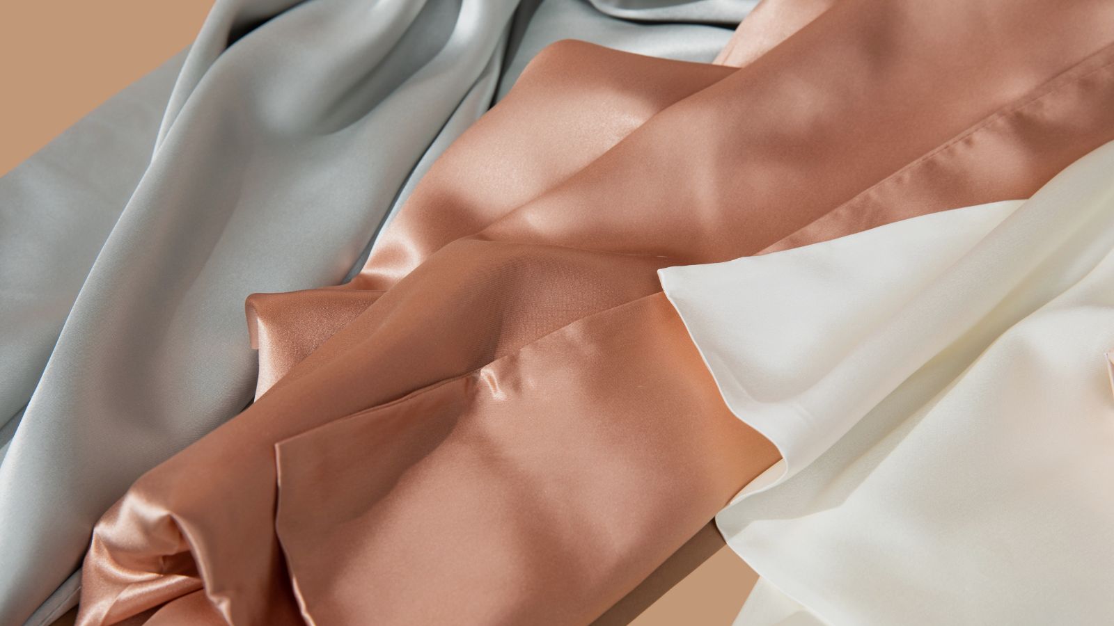 Close up shot of Ivory white, Silver, and Rose Pink Sillo silk pillowcase made with 22 momme mulberry silk woven with silver ions anti acne silk for sensitive skin and frizz hair. 