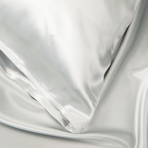 Close-up of Silver Sillo silk pillowcase — 22 Momme 6A grade organic Mulberry silk woven with silver ions for antibacterial protection, showing smooth texture, envelope-style closure, and natural sheen; gentle on skin and hair.