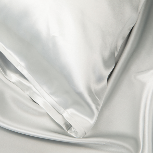 Close-up of Silver Sillo silk pillowcase — 22 Momme 6A grade organic Mulberry silk woven with silver ions for antibacterial protection, showing smooth texture, envelope-style closure, and natural sheen; gentle on skin and hair.