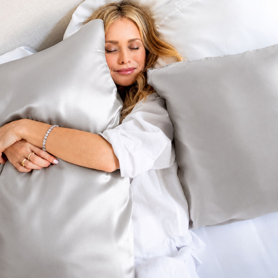 Lifestyle photo of woman sleeping on Silver Sillo silk pillowcase — soft 22 Momme organic Mulberry silk woven with silver ions for acne-prone, sensitive skin and hair; helps reduce wrinkles and signs of aging. Cooling, hypoallergenic, and gentle for daily use.