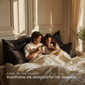 Black Sillo silk pillowcase styled on bed in modern bedroom; 22 Momme Mulberry silk woven with silver ions for acne-prone, sensitive skin and hot sleepers seeking cool, temperature-regulating, wrinkle-reducing sleep.