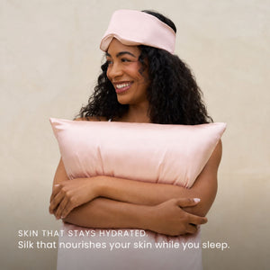 Blush Pink Sillo silk pillowcase styled on bed in modern bedroom; 22 Momme Mulberry silk woven with silver ions for acne-prone, sensitive skin and hot sleepers seeking cool, temperature-regulating, wrinkle-reducing sleep.