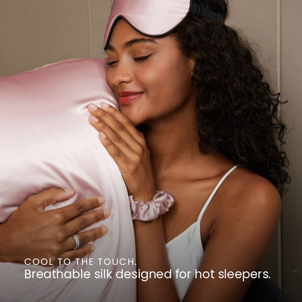 Lifestyle photo of woman holding Blush Pink Sillo silk pillowcase — soft 22-Momme organic Mulberry silk woven with silver ions for acne-prone, sensitive skin and hair; helps reduce wrinkles and signs of aging. Cooling, hypoallergenic, and gentle for daily use.