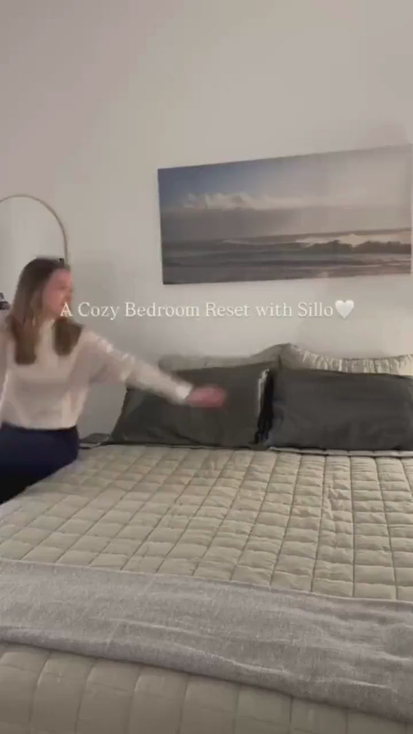 Bedroom reset featuring Sillo Charcoal Grey mulberry silk pillowcases placed on a freshly made bed, showing the smooth silk finish, premium gift packaging and an elevated nighttime sleep setup.