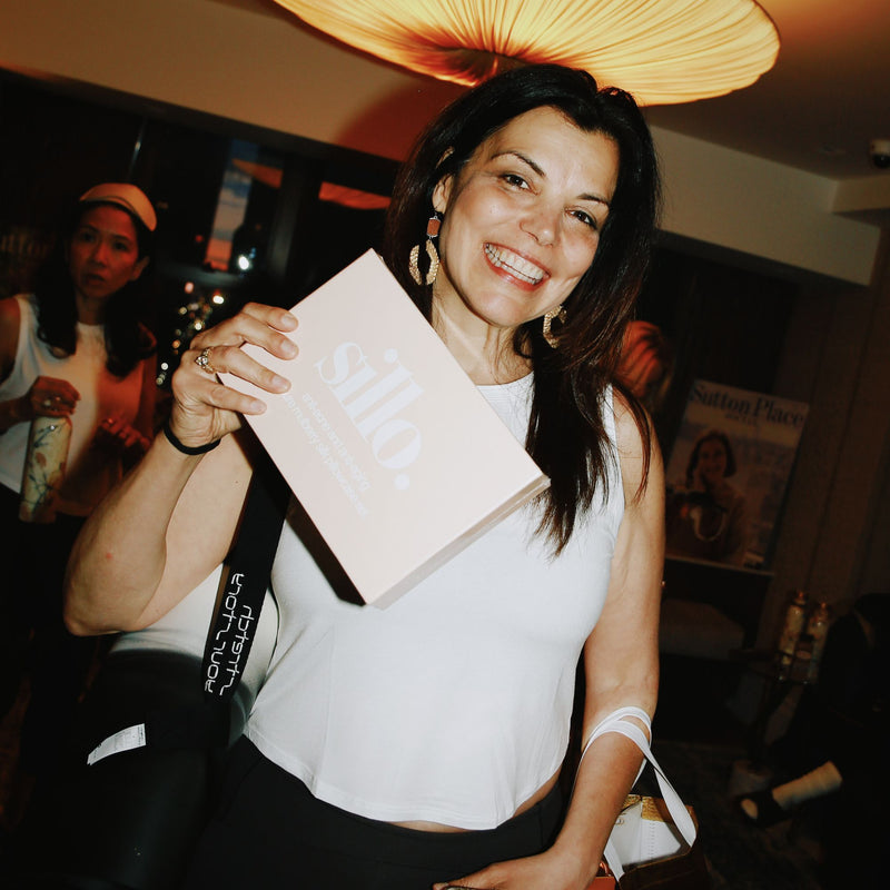 Sillo customer smiling and holding a Sillo silk pillowcase gift set, part of her acne prone skin journey
