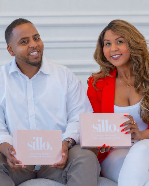 Sillo co-founders holding their silk pillowcase boxes, the brand created for acne-prone skin and frizzy hair
