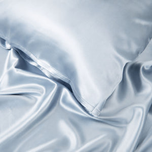 Close-up of Haze Blue Sillo silk pillowcase — 22 Momme 6A grade organic Mulberry silk woven with silver ions for antibacterial protection, showing smooth texture, envelope-style closure, and natural sheen; gentle on skin and hair.