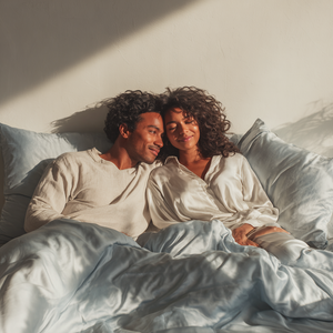 Silver Sillo silk pillowcase styled on bed in modern bedroom; 22 Momme Mulberry silk woven with silver ions for acne-prone, sensitive skin and hot sleepers seeking cool, temperature-regulating, wrinkle-reducing sleep.