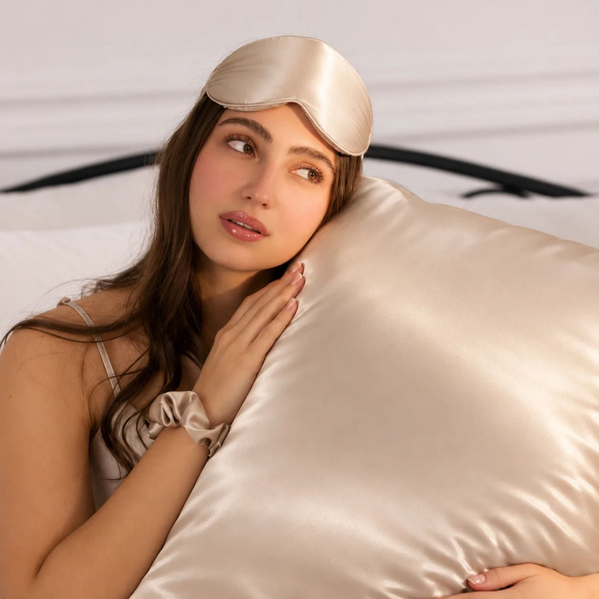 a women holding Sillo light champagne silk pillowcases, naturally hydrates skin.  A smoother, less absorbent surface lets your skin rest. Sillo silk is made for sensitive skin providing a hypoallergenic sleep surface. 